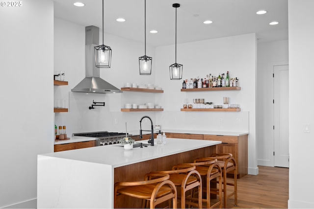 9316 NW Hardy Ave, Portland, OR 97231 - indoor dry bar featuring wall chimney range hood, light wood finished floors, recessed lighting, decorative light fixtures, and stainless steel gas stovetop
