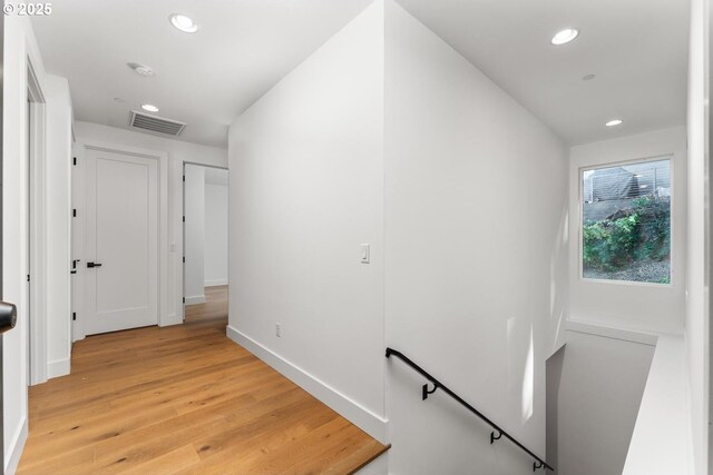 corridor featuring recessed lighting, visible vents, light wood finished floors, and an upstairs landing
