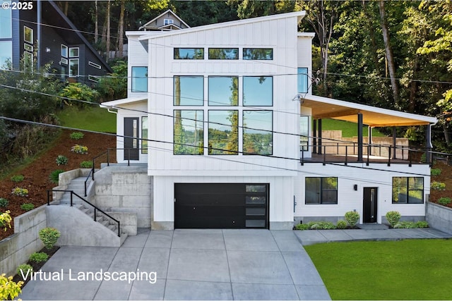 contemporary house featuring board and batten siding, an attached garage, driveway, and a balcony
