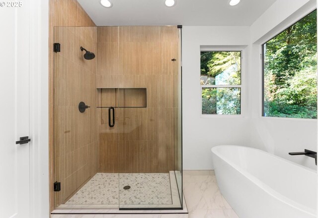 bathroom featuring recessed lighting, a freestanding bath, marble finish floor, and a stall shower