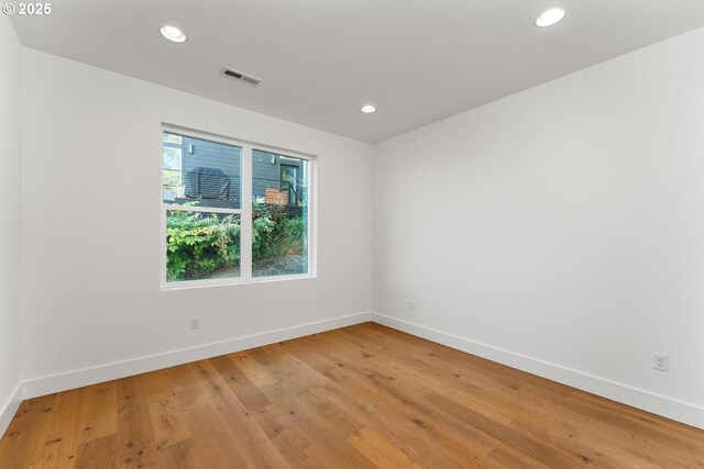 empty room with baseboards, light wood-style flooring, and visible vents