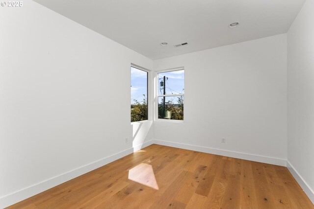 spare room with baseboards, recessed lighting, visible vents, and light wood-type flooring
