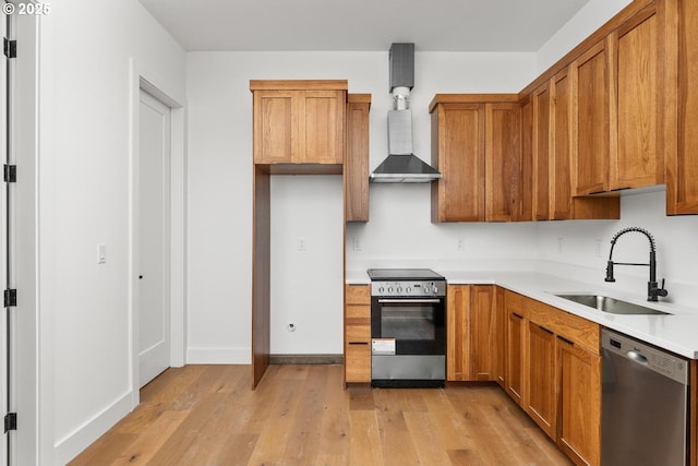 kitchen featuring brown cabinets, a sink, light wood-style floors, light countertops, and stainless steel appliances