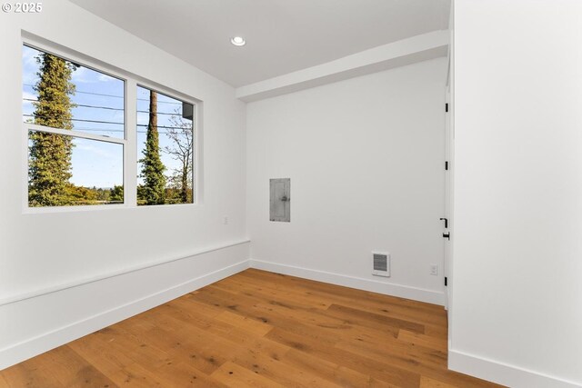 unfurnished room with light wood-style floors, recessed lighting, baseboards, visible vents, and electric panel