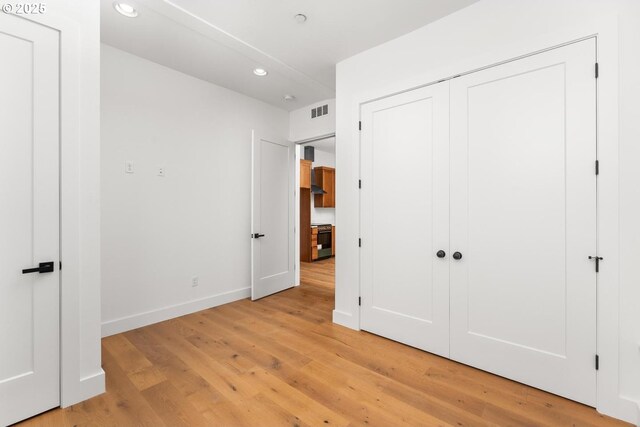 unfurnished bedroom with visible vents, baseboards, a closet, light wood-style floors, and recessed lighting