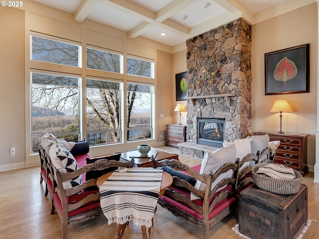 living room with coffered ceiling, beam ceiling, a fireplace, and light hardwood / wood-style floors