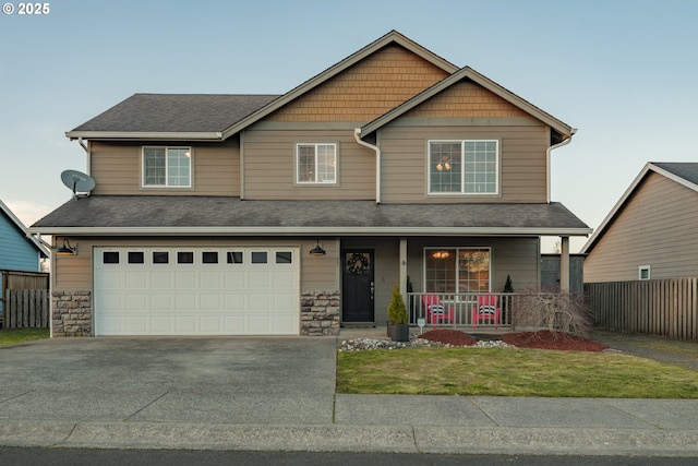 craftsman-style home with concrete driveway, a garage, fence, and covered porch