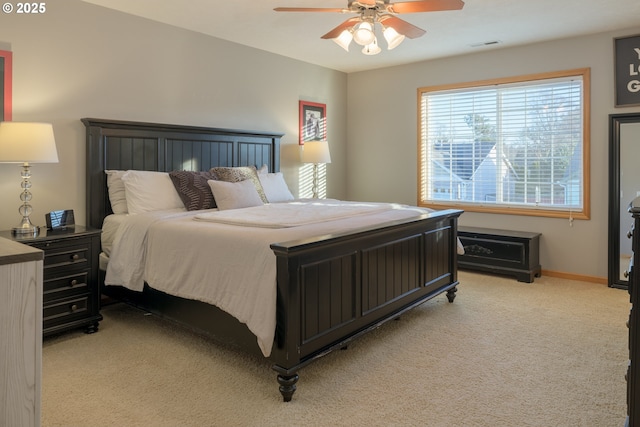 bedroom with ceiling fan, baseboards, visible vents, and light carpet