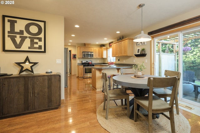 dining space featuring recessed lighting and light wood-style flooring