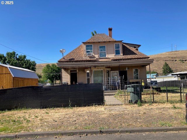 1103 SE Alexander Pl, Pendleton, OR 97801 - view of front of house with a fenced front yard, a porch, a chimney, and cooling unit