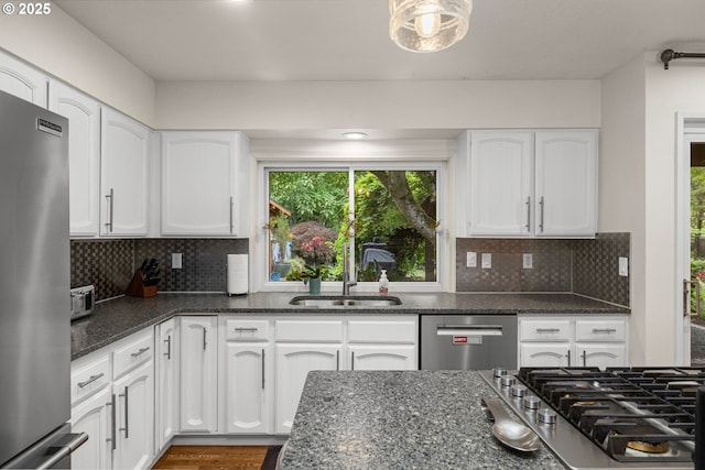 20060 SW Clarion St, Beaverton, OR 97003 - kitchen with appliances with stainless steel finishes, dark stone counters, and white cabinetry