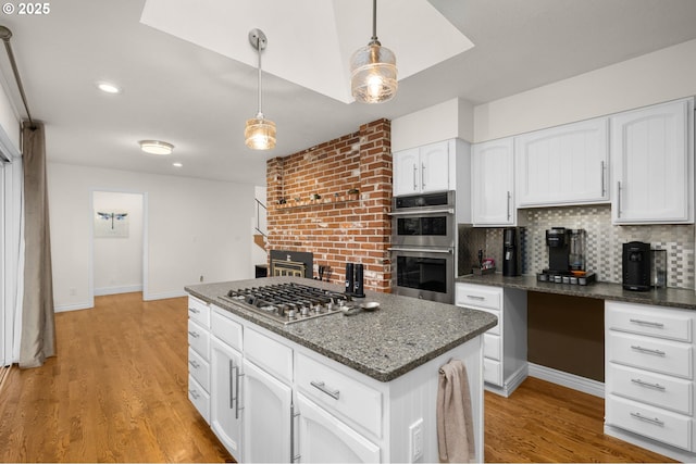 20060 SW Clarion St, Beaverton, OR 97003 - kitchen with appliances with stainless steel finishes, backsplash, a kitchen island, pendant lighting, and white cabinets