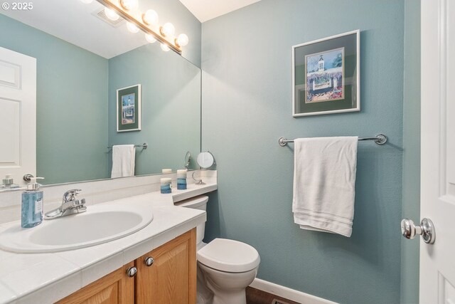 bathroom featuring vanity, baseboards, and toilet