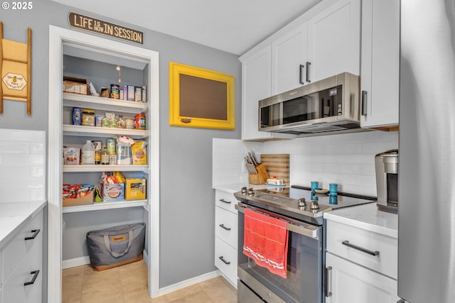 1592 NW Keasey St, Roseburg, OR 97471 - kitchen with backsplash, appliances with stainless steel finishes, light stone counters, and white cabinetry