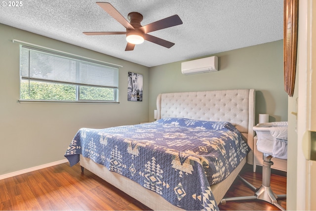 1592 NW Keasey St, Roseburg, OR 97471 - bedroom featuring a wall mounted AC, baseboards, a textured ceiling, a ceiling fan, and wood finished floors