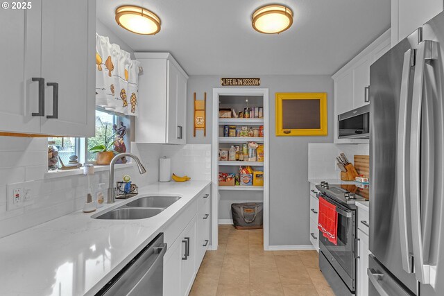 1592 NW Keasey St, Roseburg, OR 97471 - kitchen with white cabinets, light stone countertops, decorative backsplash, stainless steel appliances, and a sink