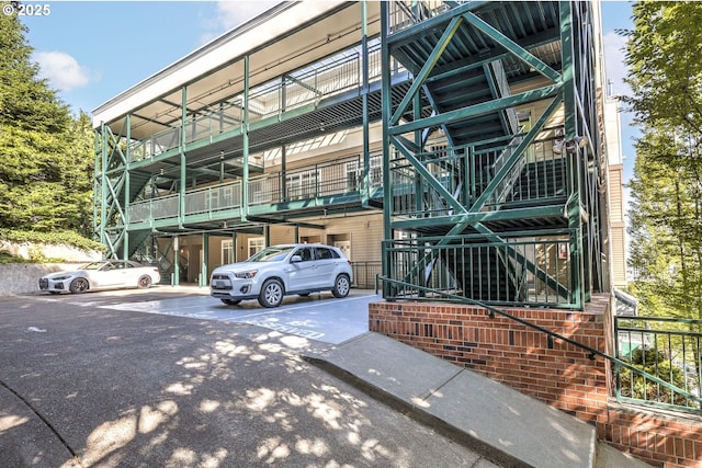 view of property with uncovered parking and stairs