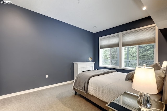 carpeted bedroom with a premium fireplace and baseboards