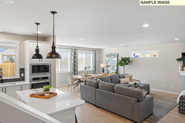 living room featuring sink and light hardwood / wood-style floors