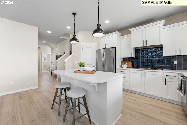 kitchen featuring a center island, white cabinets, and stainless steel refrigerator