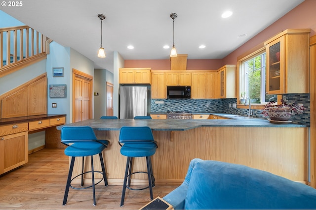 9180 Windward Ln, Manzanita, OR 97130 - kitchen with black microwave, freestanding refrigerator, dark countertops, glass insert cabinets, and a peninsula