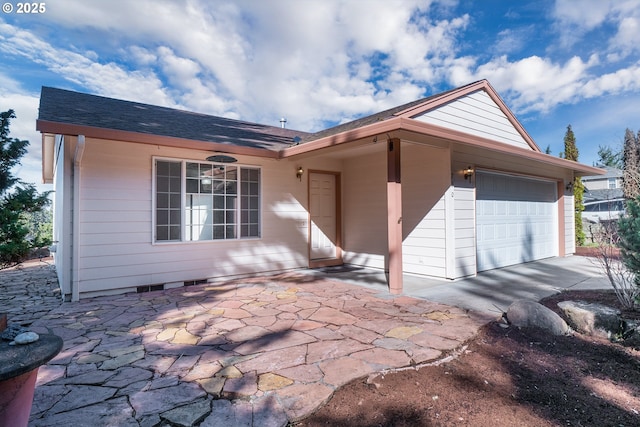 ranch-style home with a patio, a garage, and roof with shingles