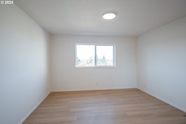 empty room featuring light wood-style floors and baseboards