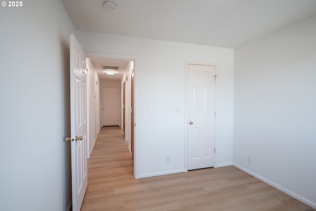 unfurnished bedroom featuring visible vents, light wood-type flooring, and baseboards