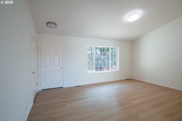 empty room featuring visible vents, baseboards, and light wood-style flooring