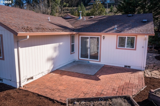 rear view of property featuring a patio, roof with shingles, and crawl space