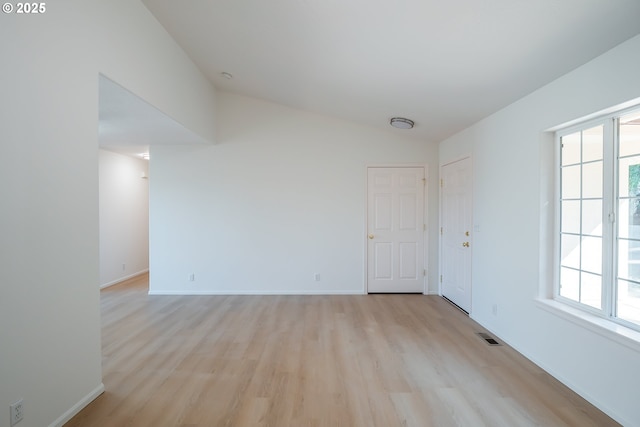 empty room with light wood finished floors, baseboards, and a wealth of natural light