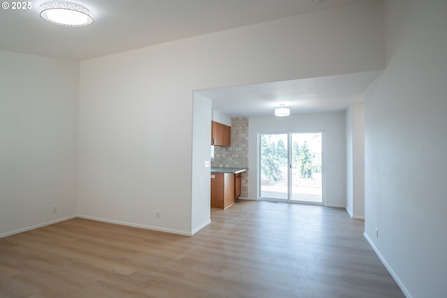 unfurnished living room with baseboards and light wood-style floors