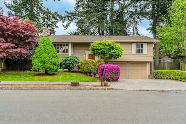 view of front facade with a garage, fence, a chimney, and concrete driveway