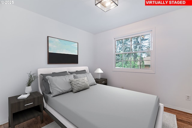 bedroom featuring baseboards and wood finished floors