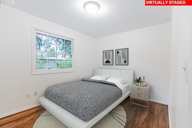 bedroom with baseboards and wood finished floors