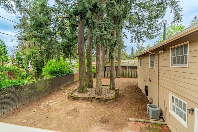 view of yard with a fenced backyard and central AC unit