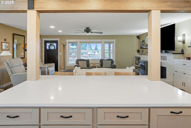 30596 Horseshoe Dr, Albany, OR 97321 - kitchen featuring open floor plan, ceiling fan, a kitchen island, light countertops, and a fireplace