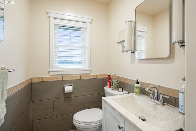 30596 Horseshoe Dr, Albany, OR 97321 - bathroom featuring tile walls, toilet, vanity, and a wainscoted wall