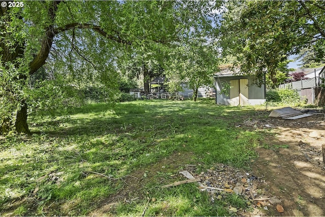 view of yard featuring fence, an outdoor structure, and a shed