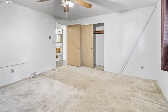 unfurnished bedroom featuring unfinished concrete flooring, ceiling fan, a closet, and connected bathroom