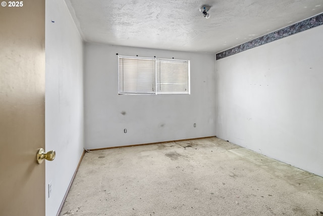 carpeted empty room with a textured ceiling