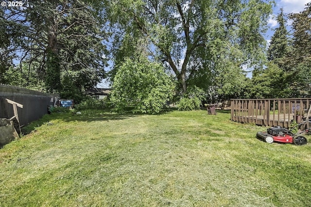 view of grassy yard with a wooden deck