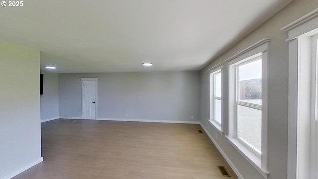 empty room featuring recessed lighting, visible vents, baseboards, and wood finished floors