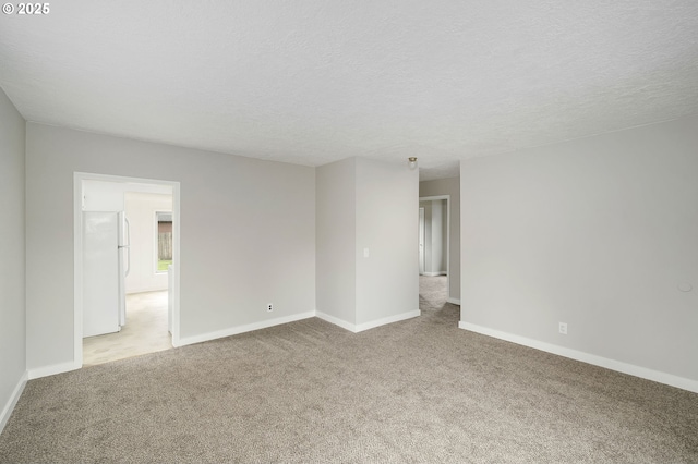 unfurnished room with light colored carpet and baseboards