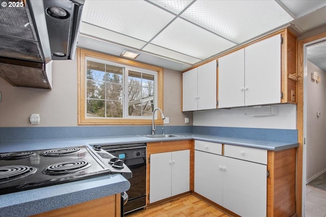 kitchen featuring light wood-style flooring, a sink, black dishwasher, white cabinetry, and stovetop