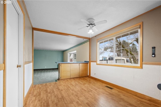 interior space featuring light wood finished floors, visible vents, baseboards, and ceiling fan