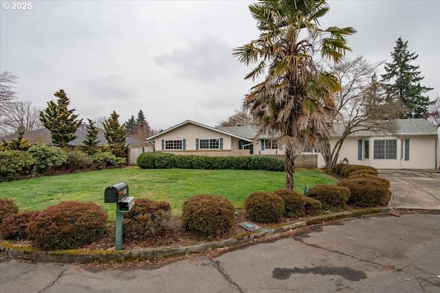 ranch-style house featuring a front yard and driveway