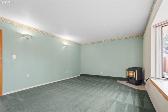 unfurnished living room featuring carpet flooring, a wood stove, and baseboards