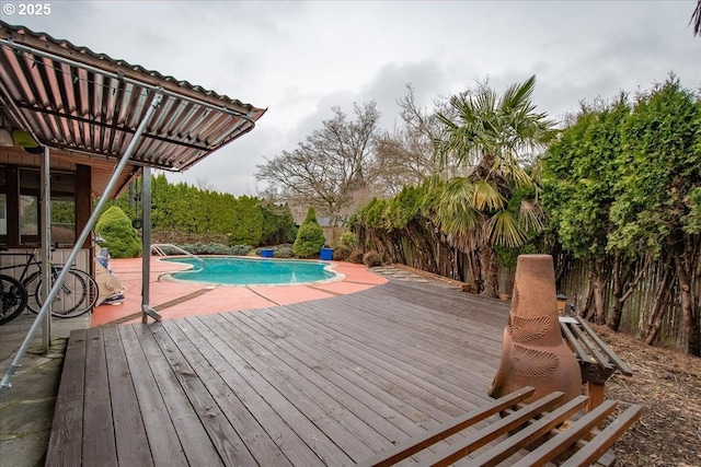 view of pool featuring a patio area, a fenced in pool, and a wooden deck