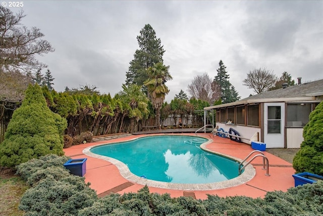 view of swimming pool featuring a fenced backyard, a fenced in pool, a patio, and a sunroom